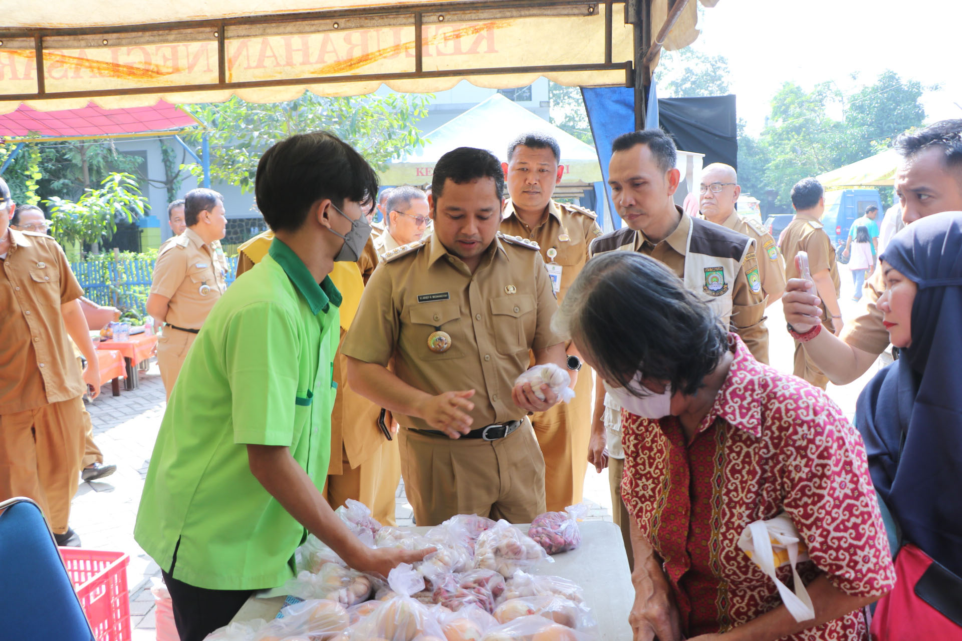 Kenaikan harga bahan pokok merupakan masalah yang sering dihadapi di berbagai daerah, termasuk Kota Tangerang. Ketidakstabilan harga ini dapat mengganggu perekonomian masyarakat, terutama bagi mereka yang berada di garis bawah. Dalam upaya menjaga kestabilan ekonomi dan kesejahteraan masyarakat, Pemerintah Kota (Pemkot) Tangerang telah mengambil serangkaian langkah strategis untuk mengantisipasi lonjakan harga bahan pokok. Artikel ini akan membahas secara mendalam langkah-langkah yang diambil oleh Pemkot, serta dampaknya terhadap masyarakat dan perekonomian lokal. 1. Strategi Pemkot dalam Mengelola Stok Bahan Pokok Salah satu langkah utama yang diambil oleh Pemkot Tangerang untuk mengantisipasi kenaikan harga bahan pokok adalah dengan mengelola stok secara efektif. Pemkot berupaya memastikan adanya cadangan bahan pokok yang cukup untuk memenuhi kebutuhan masyarakat, terutama menjelang periode-periode tertentu yang biasanya menyebabkan lonjakan harga, seperti bulan puasa dan hari raya. Pengelolaan stok ini melibatkan kerja sama dengan berbagai pihak, termasuk distributor, pedagang grosir, serta petani lokal. Dengan menjalin hubungan yang baik dengan para pelaku pasar ini, Pemkot dapat memperoleh informasi yang akurat mengenai kondisi pasokan dan permintaan bahan pokok di lapangan. Selain itu, Pemkot juga melakukan pemantauan secara berkala terhadap fluktuasi harga di pasar untuk mengantisipasi potensi masalah yang mungkin timbul. Tidak hanya itu, Pemkot juga membentuk tim khusus yang bertanggung jawab untuk melakukan pengawasan dan penanganan apabila terjadi lonjakan harga yang tidak wajar. Tim ini akan dilengkapi dengan data dan analisis yang mendalam untuk mengambil keputusan yang tepat. Dengan langkah-langkah ini, Pemkot berharap dapat menjaga kestabilan harga dan memastikan bahwa masyarakat tidak mengalami kesulitan dalam memenuhi kebutuhan sehari-hari. 2. Penyaluran Bantuan Sosial untuk Masyarakat yang Terkena Dampak Dalam situasi di mana harga bahan pokok melambung, dampak ekonomi yang dirasakan oleh masyarakat, terutama yang berpenghasilan rendah, menjadi sangat signifikan. Sebagai respons terhadap kondisi ini, Pemkot Tangerang telah meluncurkan program bantuan sosial yang bertujuan untuk meringankan beban masyarakat. Bantuan sosial ini diberikan dalam bentuk paket sembako yang berisi bahan pokok penting seperti beras, minyak goreng, gula, dan sayuran. Pemkot bekerja sama dengan berbagai lembaga dan organisasi non-pemerintah untuk memastikan penyaluran bantuan ini tepat sasaran. Proses pendataan dilakukan dengan cermat untuk memastikan bahwa keluarga yang paling membutuhkan mendapatkan bantuan yang diperlukan. Selain itu, Pemkot juga menyediakan program pendidikan mengenai pengelolaan keuangan dan alternatif sumber pangan bagi masyarakat. Kegiatan ini bertujuan untuk meningkatkan pengetahuan masyarakat tentang cara mengelola anggaran rumah tangga dan memanfaatkan sumber daya lokal yang tersedia, sehingga mereka dapat mengurangi ketergantungan pada bahan pokok yang harganya berfluktuasi. 3. Kerjasama dengan Petani Lokal dan Distributor Salah satu faktor kunci dalam mengantisipasi kenaikan harga bahan pokok adalah keterlibatan petani lokal dan distributor. Pemkot Tangerang berkomitmen untuk membangun kemitraan yang kuat dengan petani dan distributor untuk memastikan pasokan bahan pokok tetap lancar dan harga stabil. Program yang dijalankan mencakup pelatihan bagi petani tentang teknik pertanian yang efisien dan ramah lingkungan, serta memberikan akses terhadap alat dan bahan yang diperlukan untuk meningkatkan hasil pertanian. Selain itu, Pemkot juga memfasilitasi akses pasar bagi petani lokal dengan mengadakan bazar dan pameran produk pertanian. Dengan cara ini, petani dapat langsung menjual hasil panennya kepada konsumen tanpa perantara, sehingga dapat memperoleh harga yang lebih baik. Keterlibatan distributor juga sangat penting dalam menjaga stabilitas harga. Pemkot bekerja sama dengan distributor untuk memastikan mereka tidak melakukan praktik penimbunan yang dapat menyebabkan lonjakan harga. Dengan menjalin komunikasi dan kerja sama yang baik, Pemkot dapat meminimalisir risiko kelangkaan bahan pokok di pasar. 4. Edukasi Masyarakat tentang Pengelolaan Sumber Daya Pendidikan dan penyuluhan kepada masyarakat mengenai pengelolaan sumber daya merupakan langkah preventif yang tidak kalah penting. Pemkot Tangerang menyadari bahwa masyarakat perlu dibekali pengetahuan dan keterampilan untuk dapat menghadapi kondisi ekonomi yang tidak stabil. Program edukasi ini mencakup penyuluhan mengenai cara menanam sayuran di pekarangan rumah, pemanfaatan limbah menjadi pupuk organik, serta cara-cara alternatif untuk memenuhi kebutuhan pangan. Dengan pemahaman yang baik tentang pengelolaan sumber daya, masyarakat tidak hanya dapat mengurangi ketergantungan pada bahan pokok yang harganya mahal, tetapi juga meningkatkan ketahanan pangan di tingkat keluarga. Selain itu, Pemkot juga menyelenggarakan workshop dan seminar yang melibatkan ahli pertanian dan ekonomi untuk berbagi pengetahuan dengan masyarakat. Edukasi semacam ini diharapkan dapat menciptakan masyarakat yang lebih mandiri dan proaktif dalam menghadapi perubahan harga bahan pokok.