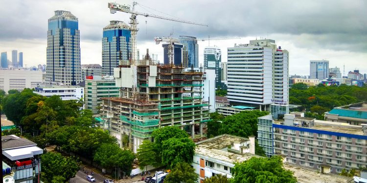 Pembangunan ekonomi di Indonesia merupakan proses yang panjang dan kompleks, dimulai sejak masa kerajaan hingga era modern saat ini. Sejarah ini dipenuhi dengan dinamika politik, sosial, dan budaya yang memengaruhi cara pandang dan strategi pembangunan yang diterapkan. Dalam artikel ini, kita akan membahas sejarah pembangunan ekonomi Indonesia dari berbagai aspek, termasuk periode pra-kemerdekaan, era Orde Lama, Orde Baru, hingga era reformasi. Dengan demikian, kita dapat melihat bagaimana perjalanan ini membentuk wajah ekonomi Indonesia yang kita kenal sekarang. 1. Pembangunan Ekonomi pada Masa Pra-Kemerdekaan Masa pra-kemerdekaan Indonesia ditandai oleh berbagai upaya pembangunan ekonomi yang dicanangkan oleh berbagai kerajaan dan koloni asing, seperti Belanda. Kerajaan-kerajaan seperti Majapahit dan Sriwijaya telah mengembangkan sistem perdagangan dan pertanian yang menjadi tulang punggung perekonomian. Namun, kedatangan bangsa Eropa, terutama Belanda, membawa dampak besar terhadap struktur ekonomi yang ada. Pada abad ke-17, Belanda mulai mengendalikan perdagangan rempah-rempah di wilayah Indonesia. Mereka menerapkan sistem tanam paksa yang mengharuskan petani untuk menanam komoditas tertentu, seperti kopi dan gula, dengan harga yang ditetapkan. Sistem ini tidak hanya menyebabkan eksploitasi terhadap rakyat, tetapi juga mengubah cara produksi yang lebih berorientasi pada pasar global. Sumber daya alam Indonesia yang melimpah, seperti minyak, gas, dan mineral, menjadi incaran bangsa kolonial. Belanda membangun infrastruktur, seperti jalan, pelabuhan, dan rel kereta, untuk mendukung pengangkutan barang-barang hasil produksi. Namun, pembangunan ini tidak dilakukan untuk kesejahteraan rakyat, melainkan untuk kepentingan ekonomi Belanda. Akibatnya, banyak rakyat yang hidup dalam kemiskinan dan ketidakadilan. Setelah Perang Dunia II, Indonesia mengalami perubahan signifikan. Proklamasi kemerdekaan pada 17 Agustus 1945 menjadi titik balik bagi bangsa Indonesia untuk mengatur ulang perekonomian, menghapus sistem kolonial yang merugikan dan mendorong pembangunan yang lebih berkeadilan. Namun, tantangan besar masih menghadang, termasuk inflasi, kekurangan pangan, dan ketidakstabilan politik. Dalam konteks inilah, pembangunan ekonomi Indonesia mulai memasuki babak baru. 2. Pembangunan Ekonomi pada Era Orde Lama Era Orde Lama, yang dimulai setelah kemerdekaan hingga tahun 1966, dipimpin oleh Presiden Soekarno. Pada masa ini, pembangunan ekonomi Indonesia berfokus pada upaya memperkuat kedaulatan nasional dan memperbaiki keadaan ekonomi pasca-kolonial. Namun, strategi yang diambil sering kali bersifat populis dan tidak selalu berdasarkan pada analisis ekonomi yang matang. Salah satu kebijakan yang diambil adalah nasionalisasi perusahaan-perusahaan asing dan penguasaan aset-aset ekonomi untuk kepentingan rakyat. Tindakan ini bertujuan untuk mengurangi ketergantungan pada asing dan meningkatkan kontrol domestik atas sumber daya. Namun, dampak negatif dari kebijakan ini adalah munculnya ketidakpastian di kalangan investor, yang berujung pada penurunan investasi dan produksi. Selain itu, era ini ditandai oleh penggunaan pendekatan ekonomi yang dikenal sebagai "Ekonomi Terpimpin". Konsep ini berfokus pada pengendalian dan pengaturan oleh pemerintah terhadap berbagai aspek ekonomi, termasuk harga dan distribusi barang. Meskipun tujuan awalnya baik, pendekatan ini menghasilkan kesulitan dalam hal efektivitas dan efisiensi, menciptakan banyak distorsi pasar. Di samping itu, sektor pertanian, yang merupakan tulang punggung perekonomian, mengalami stagnasi. Kebijakan yang kurang mendukung pengembangan sektor pertanian dan kurangnya perhatian terhadap infrastruktur menyebabkan produksi pertanian tidak optimal. Akibatnya, Indonesia mengalami krisis pangan yang berulang. Pada akhir periode Orde Lama, kondisi ekonomi semakin memburuk dengan terjadinya inflasi yang tinggi, kekurangan barang, dan protes masyarakat yang meluas. Hal ini menjadi salah satu faktor yang mendorong terjadinya perubahan kekuasaan ke era Orde Baru. 3. Pembangunan Ekonomi pada Era Orde Baru Era Orde Baru, di bawah kepemimpinan Presiden Soeharto, berlangsung dari 1966 hingga 1998. Pada masa ini, fokus utama pembangunan ekonomi adalah stabilitas, pertumbuhan, dan keterbukaan. Kebijakan ekonomi yang diterapkan cenderung lebih pro-investasi dan pro-bisnis, dengan mengundang investor asing untuk berinvestasi di Indonesia. Pemerintah Orde Baru memperkenalkan berbagai kebijakan yang mendukung pengembangan infrastruktur, seperti jalan, jembatan, pelabuhan, dan bandara. Pembangunan infrastruktur ini bertujuan untuk meningkatkan konektivitas antar daerah, mendukung industri, dan mempercepat pertumbuhan ekonomi. Sektor industri mengalami perkembangan pesat, terutama industri manufaktur, yang menjadi pendorong utama pertumbuhan ekonomi. Program transmigrasi juga diluncurkan untuk mengatasi masalah kepadatan penduduk di Pulau Jawa dengan merelokasi penduduk ke daerah lain. Meskipun program ini membawa beberapa keberhasilan, tantangan di lapangan, seperti konflik sosial dan dampak lingkungan, tidak bisa diabaikan. Namun, era ini juga diwarnai dengan praktik korupsi, kolusi, dan nepotisme (KKN) yang merajalela. Banyak proyek pembangunan yang dikelola secara tidak transparan, sehingga mengakibatkan pembengkakan biaya dan kualitas yang rendah. Masyarakat semakin tidak puas, dan kritik terhadap pemerintah semakin menguat. Krisis moneter Asia pada tahun 1997 menjadi titik awal jatuhnya era Orde Baru. Devaluasi mata uang, inflasi, dan meningkatnya kemiskinan menyebabkan banyak masalah sosial dan politik. Ketidakpuasan rakyat mencapai puncaknya dan mendorong terjadinya reformasi pada tahun 1998, yang mengakhiri pemerintahan Soeharto. 4. Pembangunan Ekonomi pada Era Reformasi Era Reformasi dimulai setelah jatuhnya Orde Baru dan berlangsung hingga saat ini. Pembangunan ekonomi pada era ini ditandai dengan upaya untuk memperbaiki tata kelola pemerintahan, transparansi, dan akuntabilitas. Sistem ekonomi yang lebih terbuka diterapkan, dengan mengedepankan prinsip-prinsip demokrasi dan memperkuat peran masyarakat sipil. Reformasi ekonomi dimulai dengan restrukturisasi sektor perbankan yang hancur akibat krisis moneter. Pemerintah melakukan berbagai upaya untuk menstabilkan ekonomi, seperti program pemulihan ekonomi nasional (PEN) dan penguatan sektor riil. Dalam hal ini, peran investasi asing kembali ditekankan untuk membantu pemulihan ekonomi. Pembangunan ekonomi juga diarahkan untuk lebih inklusif, dengan fokus pada pengurangan kemiskinan, pemerataan pembangunan antar daerah, dan peningkatan kualitas sumber daya manusia. Program-program seperti Program Keluarga Harapan (PKH) dan pembangunan infrastruktur di daerah terpencil menjadi salah satu langkah signifikan untuk mencapai tujuan tersebut. Namun, tantangan besar masih dihadapi, seperti ketidakmerataan pembangunan, korupsi yang masih mengakar, dan dampak perubahan iklim. Era reformasi juga menghadapi isu globalisasi yang membawa dampak langsung pada perekonomian Indonesia. Harga komoditas yang fluktuatif dan ketergantungan pada pasar global menjadi tantangan tersendiri bagi kestabilan ekonomi nasional. Kondisi saat ini menunjukkan bahwa pembangunan ekonomi Indonesia masih memerlukan kerja keras, inovasi, dan kolaborasi antara pemerintah, sektor swasta, dan masyarakat. Dengan komitmen yang kuat untuk membangun lebih baik, Indonesia dapat menghadapi tantangan global dan meraih masa depan yang lebih cerah.